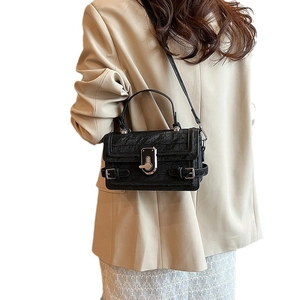 Classic black crocodile pattern crossbody flap bag with silver twist lock on model