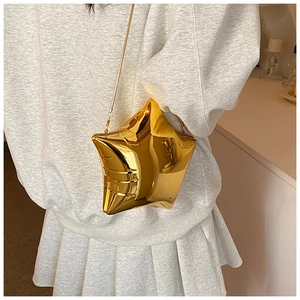 Modella che indossa una borsa a tracolla a stella dorata metallizzata con catena sottile