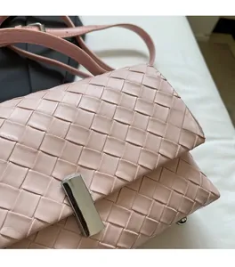 Detail of pink woven leather crossbody bag with square silver metallic buckle closure