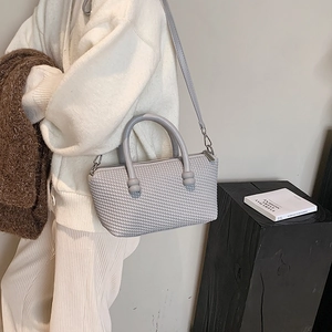 Grey textured tote bag with sphere patterns and detachable strap on minimal background