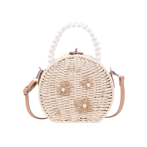 Handmade woven straw crossbody bag with pearl handle and rafia flower details