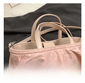 Détail du mini sac en paille avec frous-frous roses, perles et anse en cuir élégante