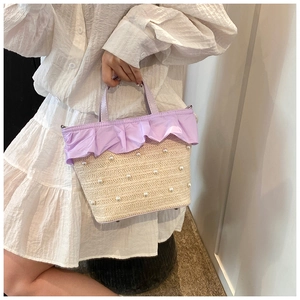 Détail du sac en paille tressée avec perles blanches et bords de poignée violets à volants