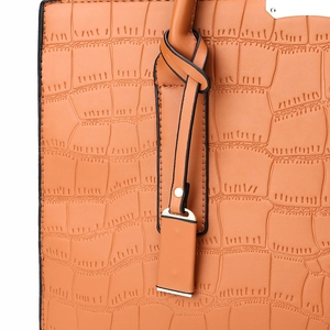Close-up of orange-brown crocodile embossed leather texture with decorative knotted strap