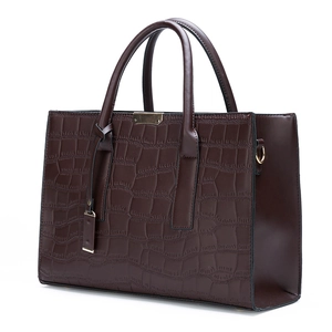 Detailed view of the dark brown faux crocodile leather texture and golden metal accents