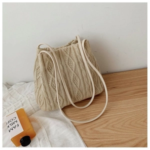 Detail of cream cable-knit shoulder bag featuring soft texture and synthetic leather straps