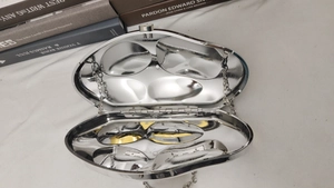 Macro detail of bean-shaped silver mirror crossbody bag with metal chain and top clasp