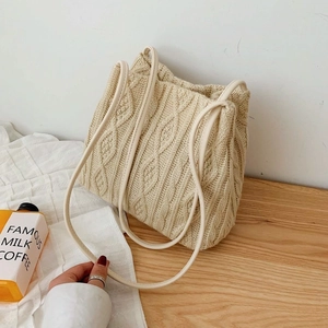 Minimalist cream knit tote bag with cable knit texture and slim leather straps