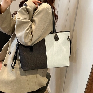 Detail of the high-capacity tote bag featuring black and white vertical contrast design