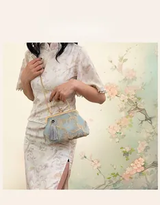 Detail of light blue satin evening bag with gold floral embroidery and metallic clasp
