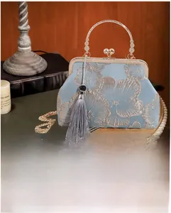 Detail of light blue silk evening bag with floral embroidery and vintage metal clasp