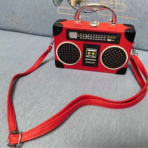 Detailed view of the red vintage boombox-shaped handbag with unique metallic handle