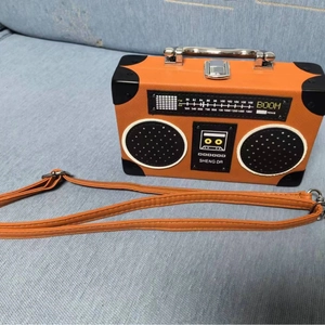 Top-down view of a creative radio-shaped crossbody bag on a blue fabric surface