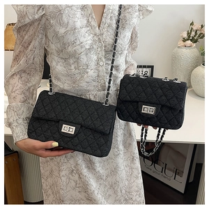 Detail of black quilted chain bags with silver metal turn-lock and woven strap textures