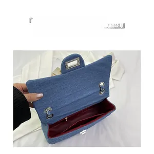 Interior detail of the denim chain bag showing spacious main compartment and inner pocket