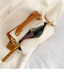 Detail of white cylindrical crossbody bag showing spacious interior for phone and cosmetics