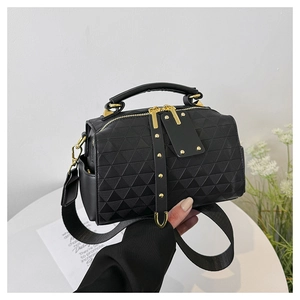 Close-up of black crossbody bag with geometric triangle embossing and gold hardware