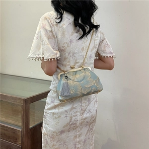 Jacquard floral evening bag with golden chain and tassel shown on a white cheongsam model