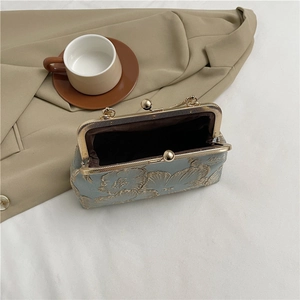 Light blue floral jacquard kiss-lock bag with gold embroidery texture and retro metal clasp