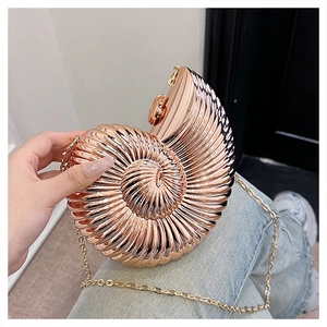 Detailed close-up of shell-shaped acrylic evening bag in rose gold with chain strap