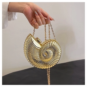 Detail of gold nautilus clutch with metallic mirror finish and radial texture