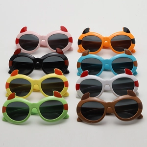 Close-up of 8 colorful cartoon devil sunglasses for kids featuring creative horn frames