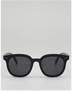 Détail de lunettes de soleil noires avec verres UV400 gris et rivets argentés discrets