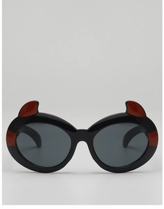 Detailed close-up of cartoon little devil sunglasses with red horns and black frame