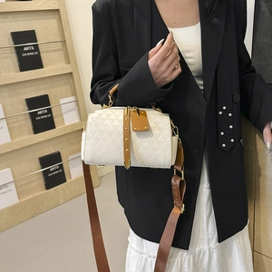 Quilted cream crossbody handbag with brown straps worn by a model in a modern office