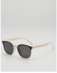 Détail de lunettes de soleil à monture crème épaisse avec verres gris et accents métalliques