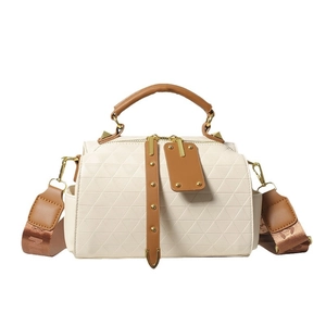 Quilted geometric cream crossbody bag with brown leather handles and wide strap