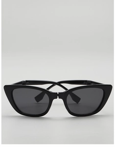 Close-up of black cat-eye kids sunglasses with dark lenses on a neutral background