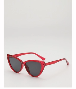 Detail of trendy cat-eye sunglasses with transparent red frames and dark grey lenses