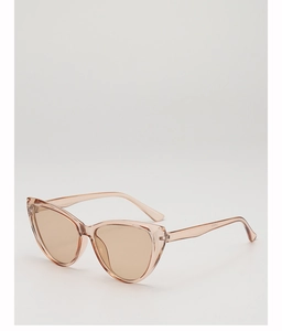 Detailed macro shot of translucent champagne cat-eye sunglasses with light brown lenses