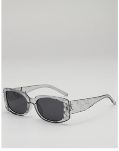 Detail of gray translucent square sunglasses featuring unique geometric textured frames