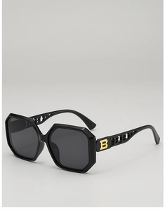 Detail showing gold hollowed-out B logo patterns on black geometric sunglasses temple