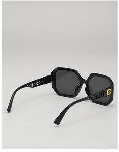 Macro shot of oversized polygonal sunglasses featuring hollowed-out B-letter metal hinges