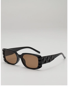 Detail of black rectangular sunglasses with 3D geometric embossed texture and brown lenses