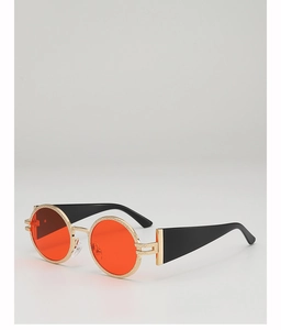 Detailed close-up of retro round orange lenses with textured golden metal frames