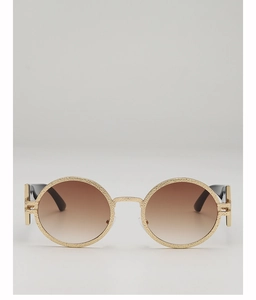 Detail view of retro round sunglasses with gold hammered texture and brown gradient lenses