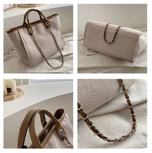 Detail view of beige canvas tote bag with brown leather trim and chain shoulder strap