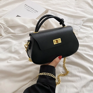 Close-up of black PU leather bag with golden twist lock and textured chain strap