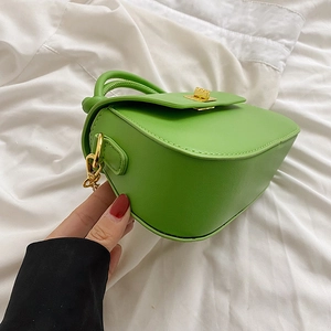 Close-up of grass green crossbody bag with textured PU leather and golden hardware