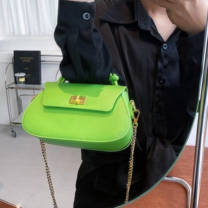 Close-up of fluorescent green leather bag with gold twist lock and metal chain strap