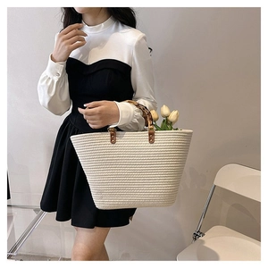 Detail of woven tote bag featuring bamboo top handles and premium cotton rope craftsmanship