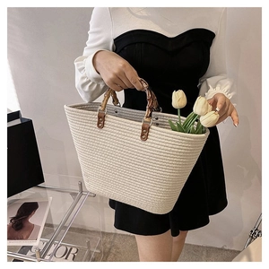 Detail of woven tote bag with authentic bamboo handles and elegant tulip decoration