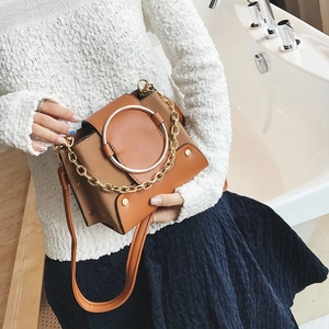 Detail of color-block brown and khaki PU leather crossbody bag with large metal ring