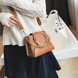 Detail of crossbody bag with silver ring buckle and gold chain strap in side view