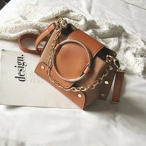 Detail of vintage suede crossbody bag with golden ring ornament and chunky chain strap