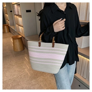 Close-up of woven tote bag with pink stripes and ergonomic bamboo top handles